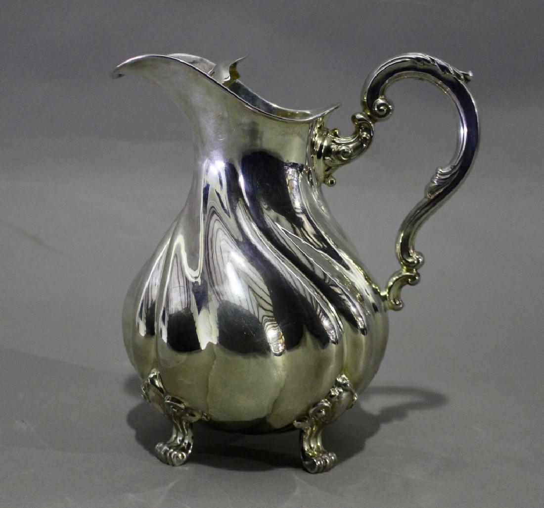Art Deco Silver Water Pitcher: Sprizter & Fuhrmann Art Deco sterling silver water pitcher with removable ice strainer, footed, swirl body, good condition with no dings or dents. 23 ozt.