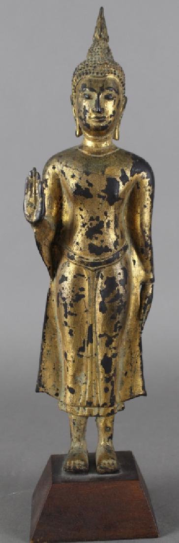 Tibetan Gilded Bronze Deity: Tibetan gilded bronze standing deity, 14" on wood trapezoidal plinth, flowing robe, right hand raised, some loss to gilding, c. first quarter of 19th century.