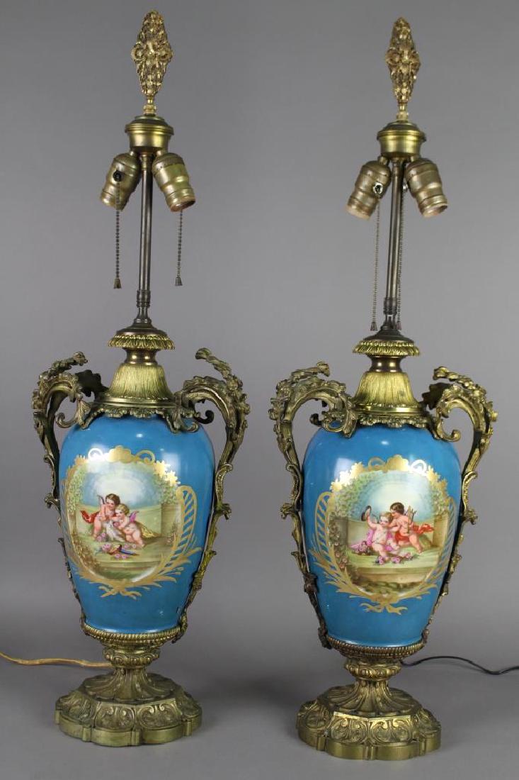 Pair Hand Painted Elegant Table Lamps: in porcelain most assuredly Sevres c.1930s, fitted with heavy bronze ormolu from top to bottom, royal French blue background with medallion scenes of playful putti on one side and still life bouquets 