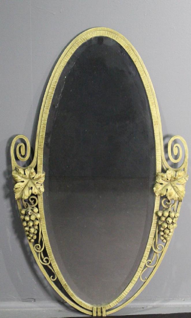 French Art Deco Wrought Iron Oval Mirror: beveled glass, c. 1925, 40" x 24", applied grape clusters on sides, wooden back marked "Made in France", small no harm flake on bevel edge, some paint chipping on metal, this too, no harm.