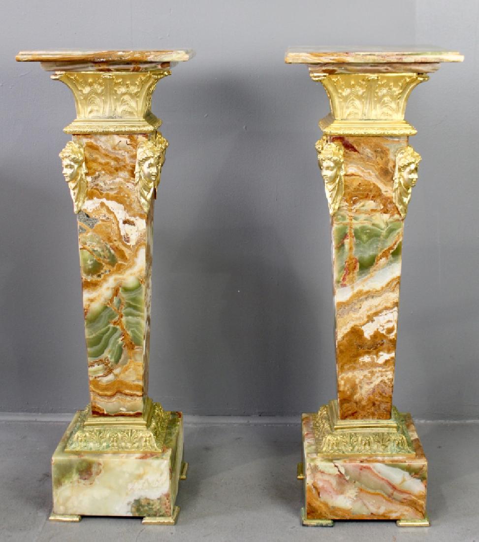 Pair of Onyx Pedestals: gold ormolu mounts and decoration, beautiful coloration in the stone, 41" x 14" square top, good condition.