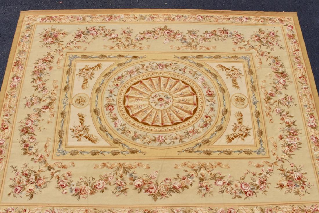 French Aubusson Rug 12.1' x 8.10': neutral and gold colors with central geometric medallion and wide borders of blooming roses, handmade with exposed back.