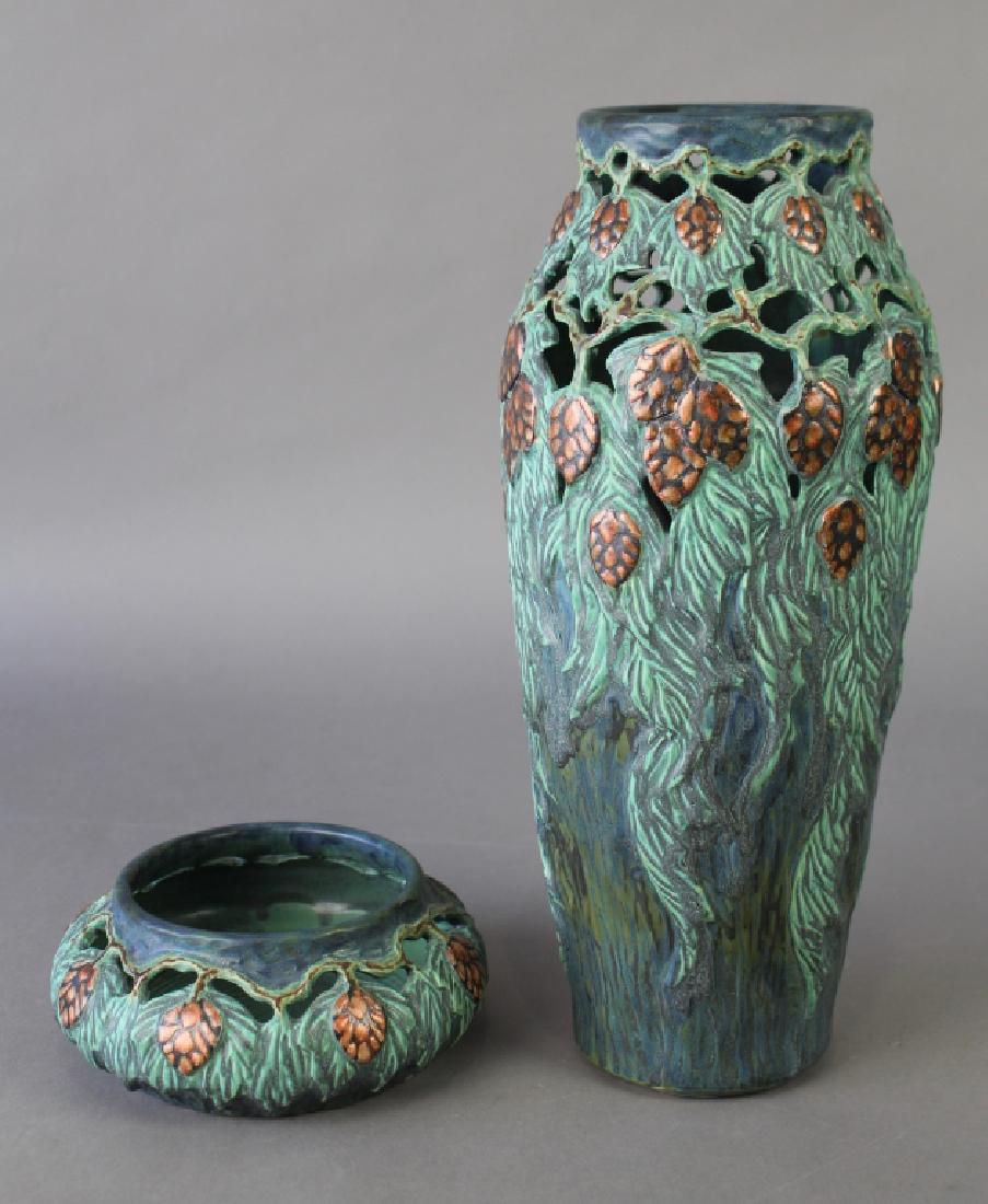 2 Pieces Florida Faience Art Pottery: a 15" reticulated vase and a 3" x 7.5" reticulated bowl, both decorated with pinecones and needles, both artist signed by Martin Cushman, both in good condition, free from defects.