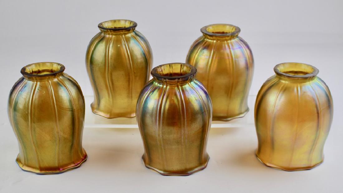 Five Iridescent Lamp Shades: bellflower shape, ribbed, three are signed LCT but we do not believe they are Tiffany. 5" tall with 2" collar, good condition.