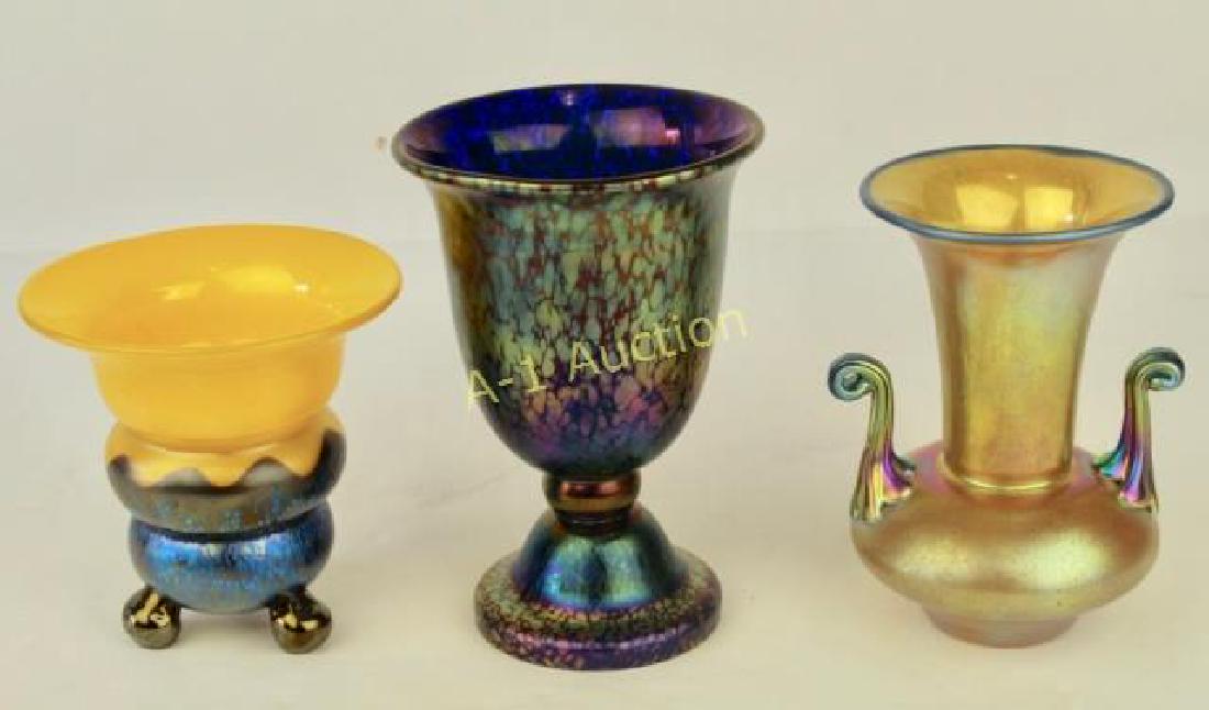 Three Czech Art Glass Pieces: a 6.5" purple oil spot foot vase, a 5.75" gold iridescent vase with applied curled handles and a super 4.75" vase on ball feet with bright yellow top and blue oil spot iridescent bottom, each signed i