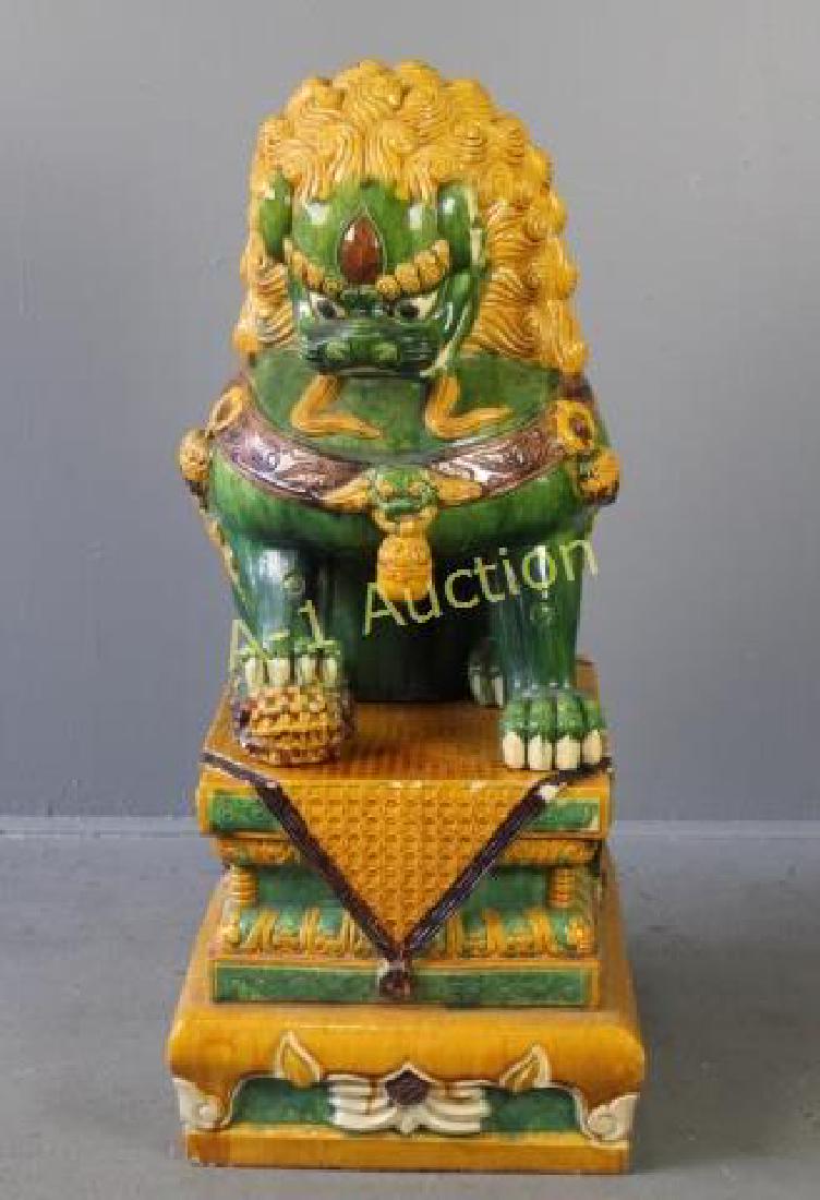 Large Chinese Temple Lion on Pedestal: 2 pieces, gold curly mane, green body, ferocious snarl, draped stand, some minor edge chipping, no cracks or missing chunks, 41" tall x 19" x 22" pedestal.