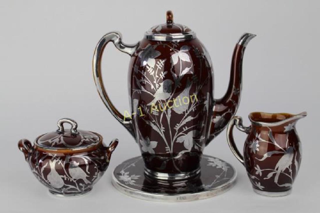 Lenox Porcelain & Silver Coffee Set: 8.5" pot, creamer, sugar and trivet with heavy floral sterling overlay on standard brown glaze, black wreath mark, c. 1905, some overlay missing on sugar bowl, otherwise good codition.
