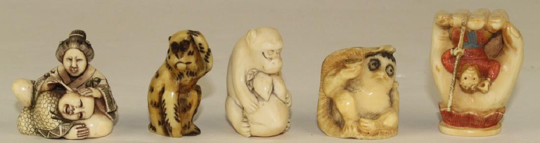 Five Japanese Netsukes: polychrome man with staff in large hand, 2", woman cleaning ear of man with head in her lap, 1.5", early monkey 1.75', whimsical duck with bottle under a leaf 1.5" damaged ear.
