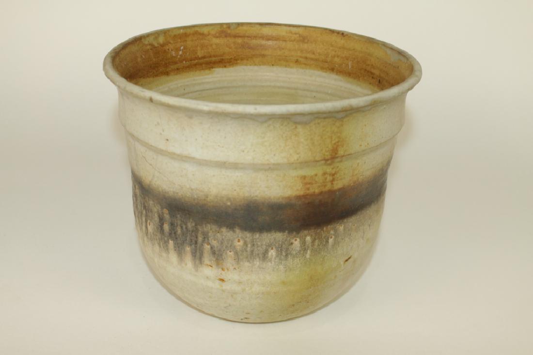 Toshiko Takaezu, Pottery Vase: American,1922-2011, fine ceramic hand thrown pot with light earth tone glaze, dark band encircling with drip, 7.75" x 9" diameter, signed "TT", good condition.