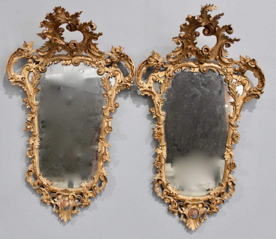 Pair Early 19th Century French Mirrors: heavily carved all around with overhanging crests, silvering in poor condition, repairs and restoration to frames evident, mostly intact, 47" x 27" x 13".