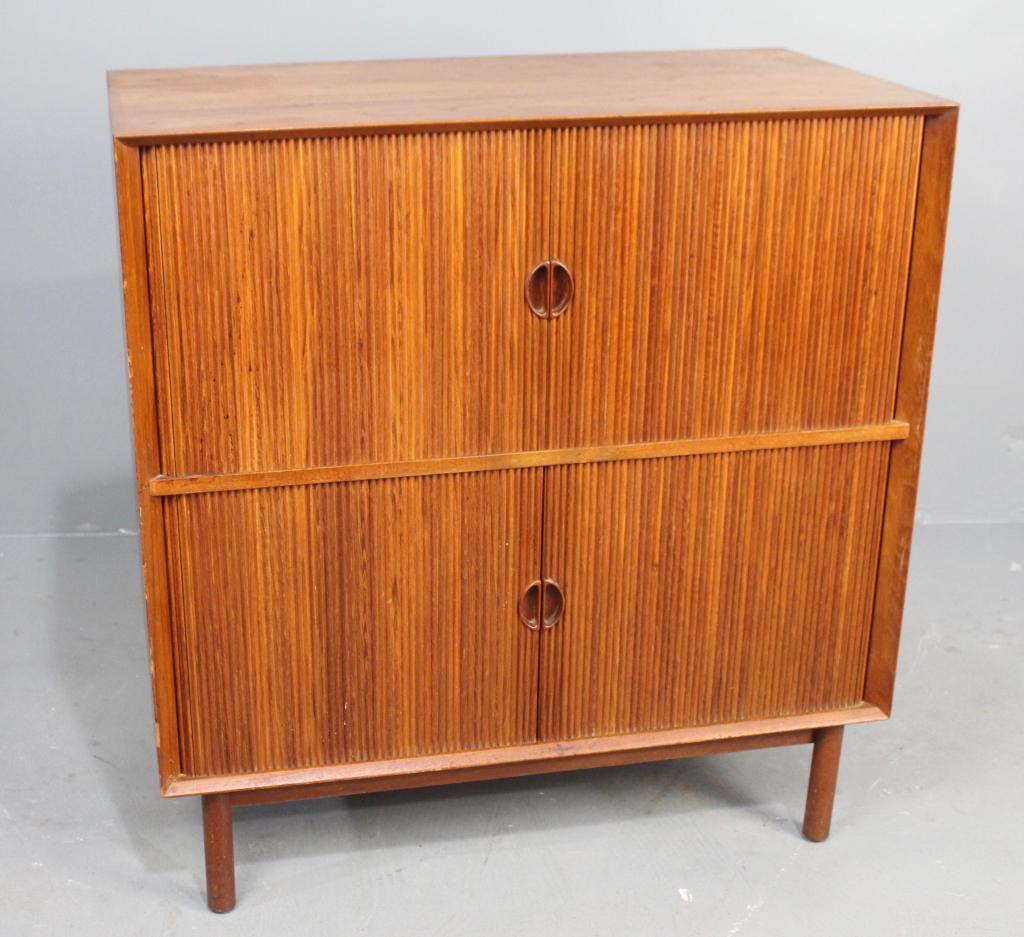 Danish Mid-Century Modern Tambour Cabinet: Teak with square dovetailed joinery on edges, 3 inner shelves, 2 are adjustable, top and bottom doors. Partial foil label on back "Skodborg" Mobel Fabrik, with Danish control seal. Purchased by consig