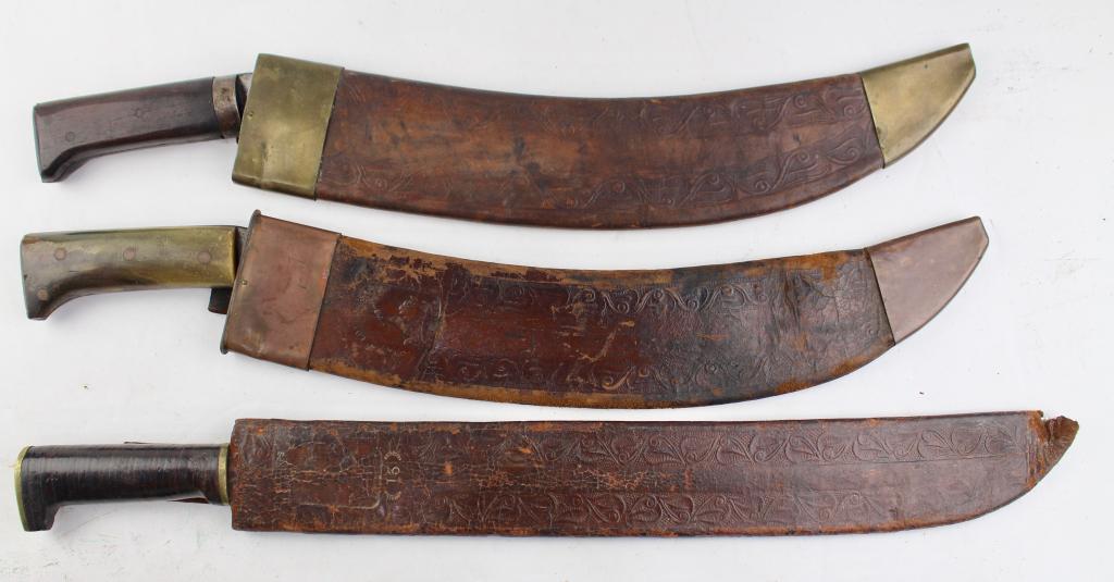 Three US Made Jungle Machetes: two marked Collins & Co. (Engineers) Hartford, CT. no. 1005 and the other #ISGNY16, with stacked leather grip, other grip appears to be bone, the other is unmarked in leather sheath with brass top and
