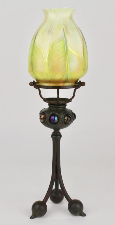 Tiffany Studios Tri-leg Candle Lamp: blown out glass around font, dark bronze with original patina, cased glass pulled feather shade is a replacement but works well with it. Impressed signature and logo stamped on feet, 14.5, good condit