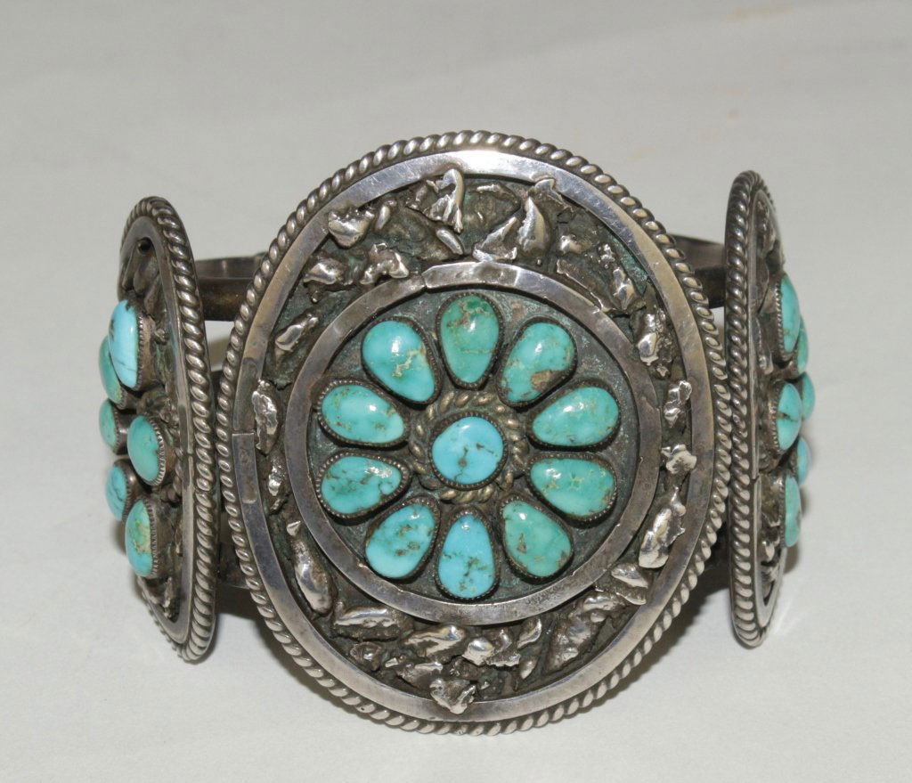 Old Pawn Zuni Turquoise and Silver Bracelet: stones set in 3 medallions with free form designed nuggets and rope braid bezel, heavy 3 ozt, unsigned, late 40s, fine condition and patina. Center medallion 2.25" x 1.6", bracelet 2.25" side to side.