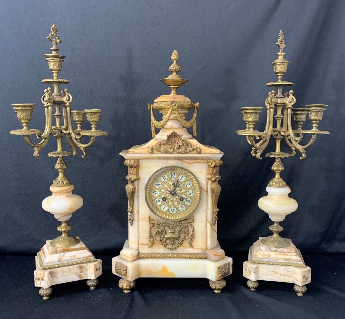 S. Marti Marble Medaille De Bronze Clock & Candelabra: S. Marti Marble Medaille De Bronze Clock & Candelabra. Bronze and gilded mantel and candelabra. Clock measures 21" x 9" x 7". Clock has damage on corners of the marble, see photos. Candelabra's measur