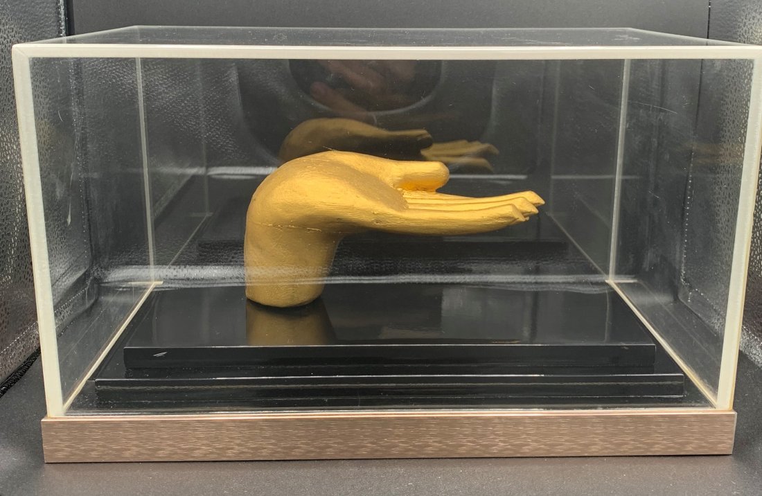 Golden Hand of Buddha Sculpture by Greg Copeland: Golden Hand of Buddha Sculpture by Greg Copeland. From the 1970's framed in plexiglass case. Measuring 14 1/2" 8 1/2" x 9". Overall condition is very good.