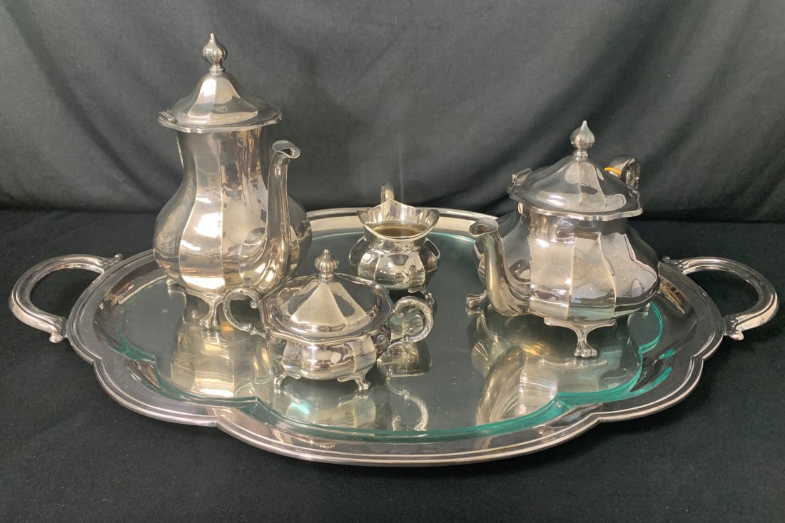 5 Pc. Sterling Silver Tea Set E. Ferner 65.6 OZT: 5 Pc. Sterling Silver Tea Set E. Ferner 65.6 OZT of sterling silver. Tray is silver plate and has a glass top. Tea pot measures 8" x 8" x 11". Coffee Pot measures 10" x 11" x 6". Creamer measures 6" x