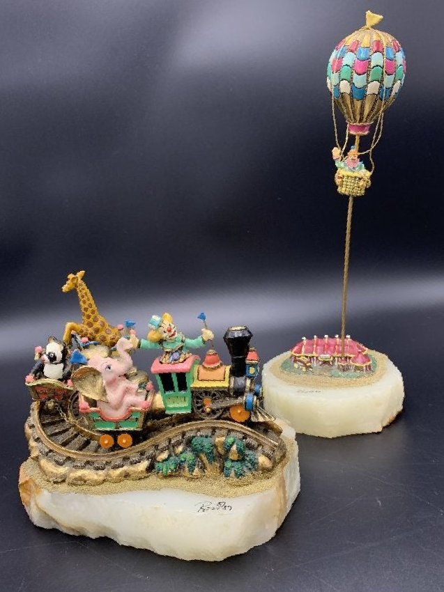 2 Vintage Ron Lee Circus Figurines on Natural Bases: 2 Vintage Ron Lee Circus Figurines on Natural Bases. Circus train measures H- 6" X W- 7" X D- 5" signed and numbered 610/3500. Circus clown in hot air balloon figurine measures H- 12" X W" 5" X D- 4" 