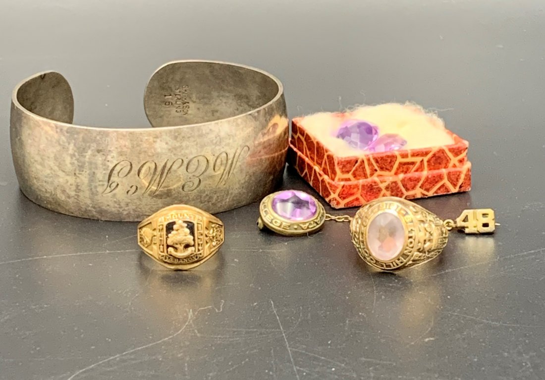 Estate Lot of 10K Yellow Gold/Sterling/Gem Stones: Estate Lot of 10K Yellow Gold/Sterling/Gem Stones. Two 10K Yellow gold class rings. 10K Yellow gold sweater pin. Two amethyst gem stones. Sterling silver cuff bracelet weighing 1.3 OZT. Total gold wei