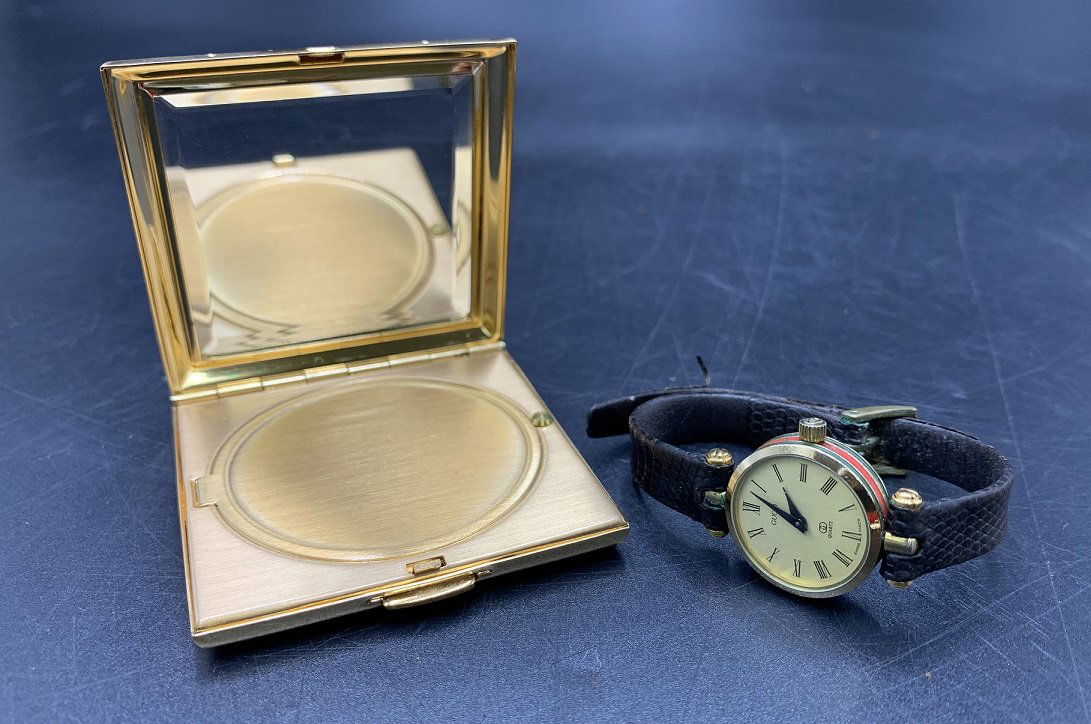 Vintage Gucci 18k Gold Plated Watch & Compact Mirror: Vintage Ladies Gucci 18k Gold Plated & Compact Mirror. Gucci 18k Gold Plated Round Stack Watch 2000L with leather band. Watch face measures 21mm. Gucci red & gold pocket compact mirror. The Gucci comp