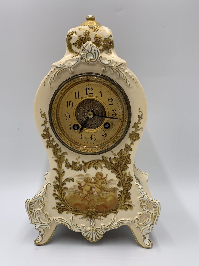Porcelain Mantel Clock with Decoration of Cherubs & Flowers.: Porcelain Mantel Clock with Decoration of Cherubs & Flowers. Makers name on dial "Spaulding" "Chicago & Paris" Longwy France. Measurements: 11 1/2tall x 6 1/2" wide x 4 1/4" depth. Weight: 5lbs. 2 oz.