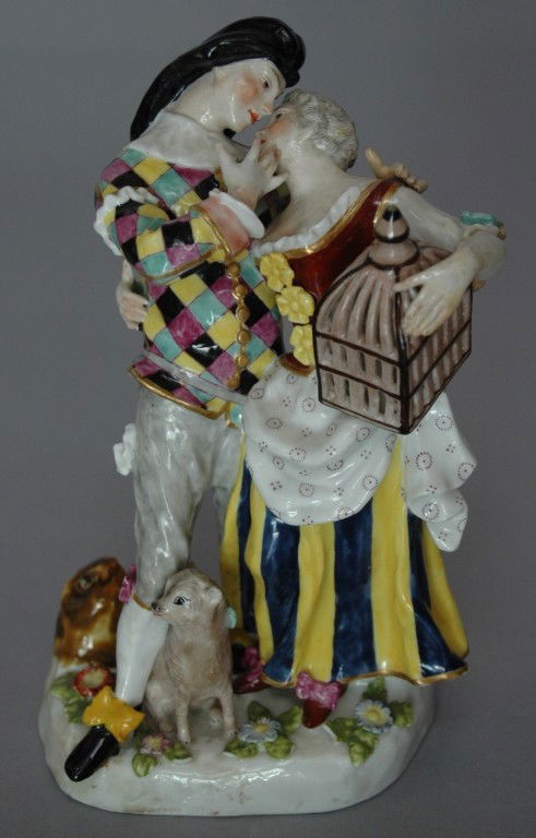 MEISSEN DOUBLE FIGURINE: MEISSEN PORCELAIN DOUBLE FIGURINE OF JESTER AND YOUNG LADY HOLDING BIRDCAGE, DOG, 7.25" CROSS SWORD MARK, PROFESSIONAL RESTORATION TO MAN'S ARM ON SHOULDER.