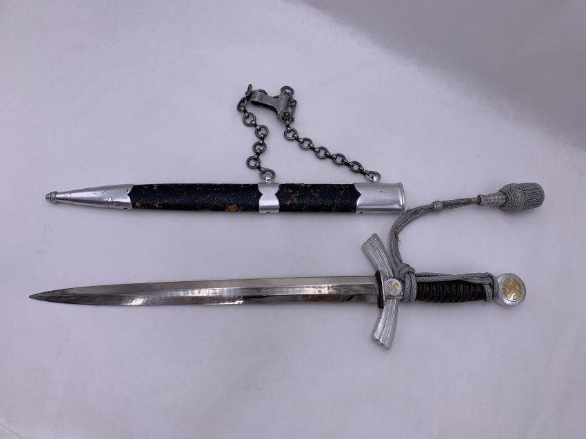 German WWII Luftwaffe Dagger by TIGER with Belt Hanger: German WWII Luftwaffe Dagger by TIGER with Belt Hanger. This Nazi dagger blade measures 12" length x 1" wide. Handle to tip of blade measures 18" length. Makers mark on the blade. The leather on the s