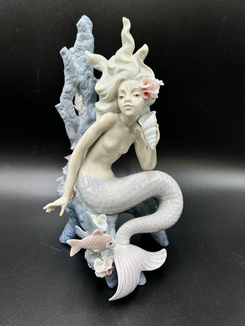 Lladro Ocean Beauty Porcelain Figurine No.5785: Lladro Ocean Beauty Porcelain Figurine No.5785. This beautiful porcelain mermaid holding a seashell & flowers in her hair was first issue in 1991. The figurine measures 10" tall x 6' wide. Weight: 1 L