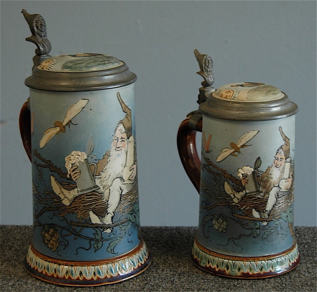 2 Mettlach Steins # 2134 .5L 1L: 2 Mettlach steins # 2134 each, .5L and 1L, Drinking Gnome, Rooster at sunrise lid, pottery and pewter lids, one good condition, smaller one has stress fracture in lid.