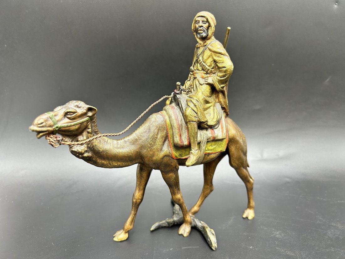 After Bergman Arab Warrior on Camel Cold-Painted Austrian Bronze: After Bergman Arab Warrior on Camel Cold-Painted Austrian Bronze. Piece depicts a Arabian warrior holding his rifle, looking afar while on his camel. Stamped AUSTRIA under saddle blanket. The figure m
