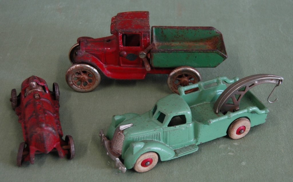 3 Toy Cars Hubley and Arcade: Group of 3 toy cars- red Hubley 5" racer, 7" Hubley green tow truck with rubber wheels, and Arcade dump truck, all with original paint, good condition.