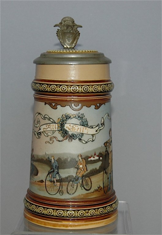 Mettlach Stein # 2190: Mettlach stein # 2190, bicyclists on boneshakers, advertising lid, pewter & pottery lid, .5L, good condition.