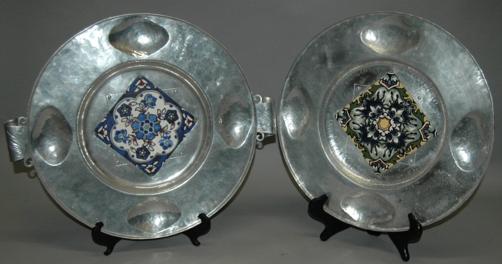Cellini Craft Hand Wrought Trays: Cellini - Craft hand wrought aluminum tray in the Arts & Crafts style, each with inset decorated tile, 20 dia with handles, 16.5 dia. Artist signed "MW" and "Cellini-Craft Hand Wrought Artgental", bot