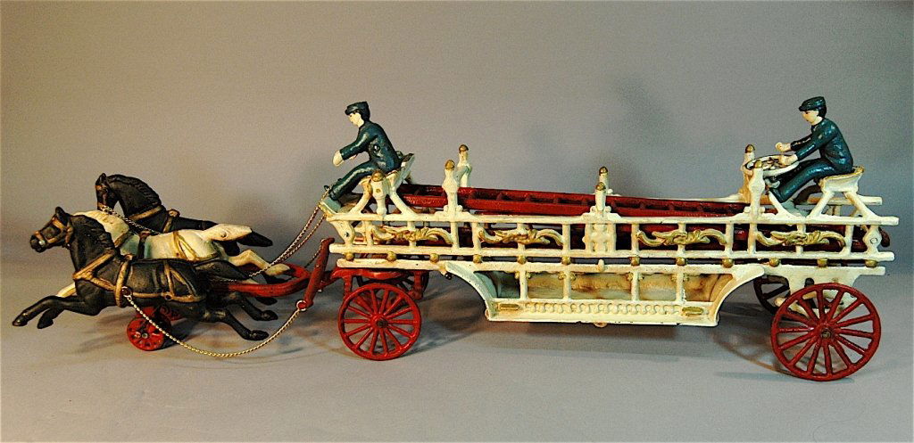 Cast Iron Hook and Ladder Toy Fire Wagon: Cast iron hook and ladder toy fire wagon, pulled by 3 harnessed horses that move up and down when rolled. 2 Firemen (1 driver, 1 on back), 3 ladders, marked "Made in U.S.A" on side of wagon, other wor