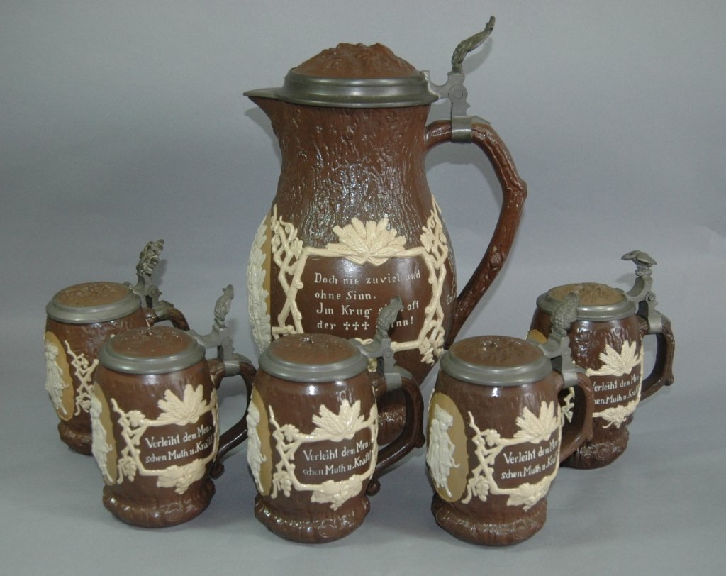 Mettlach 3L Flagon with 5 Matching Steins: Mettlach 3L flagon with 5 matching .5L steins # 1028, pottery and pewter lid. Flagon is 12.5h, 2 thumb-rests on steins are odd, very good condition.