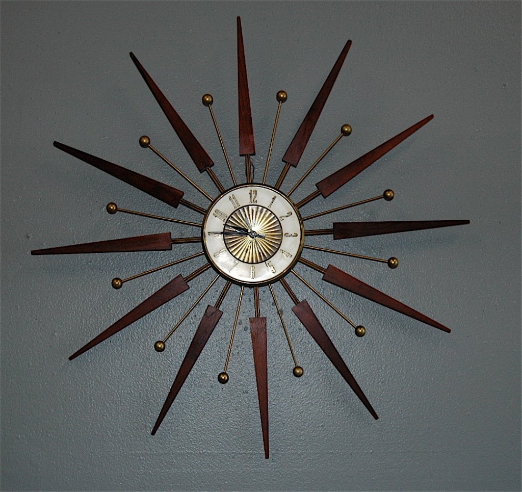 Starburst Wall Clock: Mid-century modern starburst wall clock, 30" d. walnut rays, alternating with brass rods and balls, quartz movenment needs replacing. No visible maker, good condition.