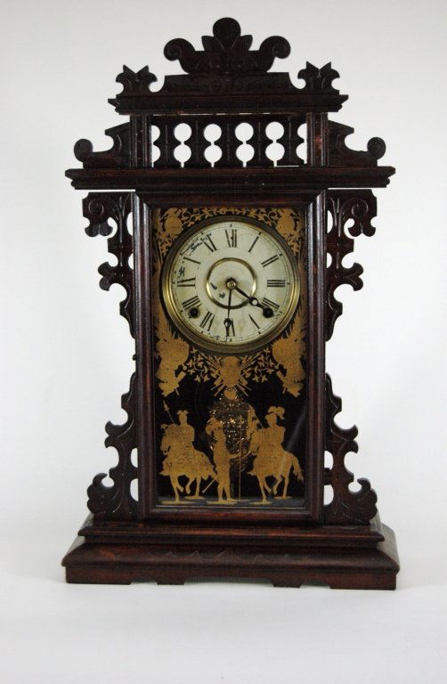 Gingerbread Kitchen Mantle Clock: Late 19th century gingerbread kitchen mantle clock, very ornate dark walnut case with gold reverse painted cavaliers on door, ornate pendulum, probably Gilbert or Ingraham, good condition. 24" h, 13"