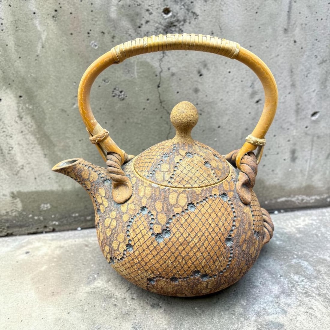 1987 Don McWhorter Signed Snake Skin Stoneware Teapot with Lid: 1987 Don McWhorter Signed Snake Skin Stoneware Teapot with Lid. This is a very unique textured pottery piece by artist Don McWhorter. In shades of brown snakeskin design with rafetta wrapped handle. S