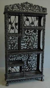 Chinese Carved Etagere: Chinese carved etagere with ebony finish, 4 ball and claw feet, dual dragon crest top, dragon carved posts, staggered shelving, exceptional condition for intricacy. 81H, 39W, 16D.