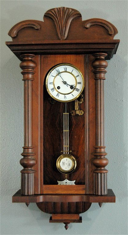 Vienna Regulator Wall Clock: Vienna regulator wall clock, walnut case with carved crest and reeded columns. Rosewood matched grain interior. 34 x 16. Very good condition.
