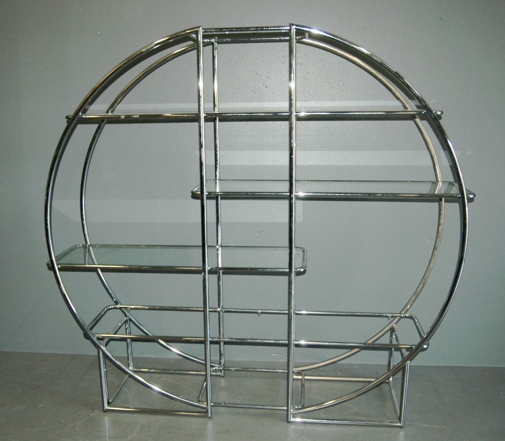 Mid-century Modern Etagere: in high polished chrome and glass shelves. In the style of Milo Baughman. This well designed shelving unit features circular tubing and 6 staggered shelves. Good condition. 68H, 73W, 18D.