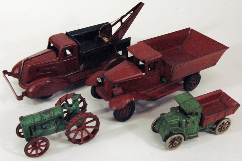 Group of 4 Toys: Group of 4 toys: Girard red pressed steel dump truck, Arcade cast iron green and red tractor, Arcade green and red dump truck, unmarked pressed steel red and black tow truck. Condition consistent with