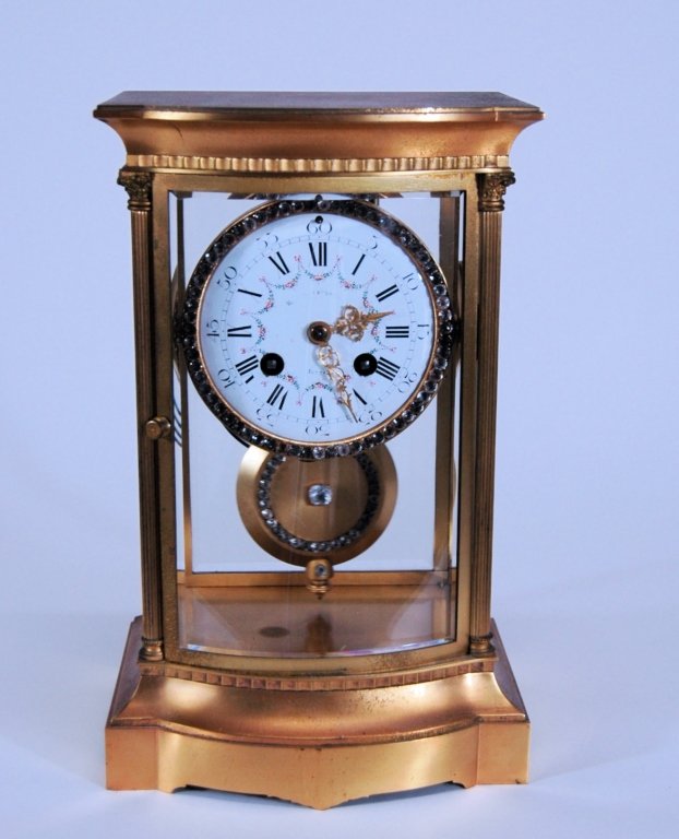 French Crystal Regulator Clock: French Crystal Regulator mantle clock, rhinestone encircling dial and pendulum, porcelain face. Minor flaking around winding holes. Indiscernible name on face but Boston is clear. Clock works by Marti