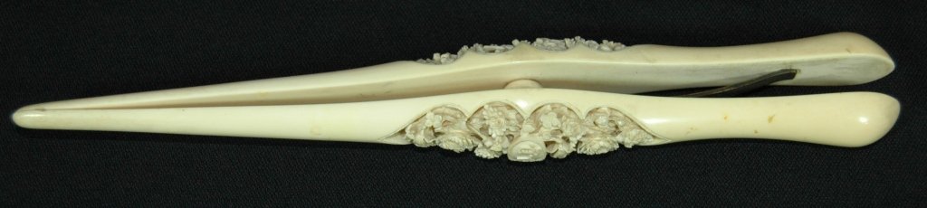 Chinese Ivory Glove Stretcher: Victorian Chinese carved ivory glove stretcher, c. 1850-60, deeply carved 3-D florals on one side, scenic village on other, very good condition, 10.5".NOTE: Ivory cannot be shipped internationally, no