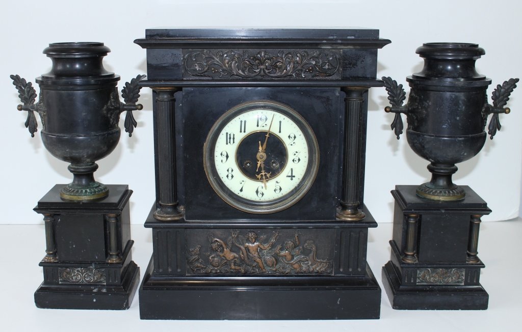 French Clock Set: French clock set, 3 pieces, heavy black marble case and garniture vases with applied bronze ormolu. clock front has bronze frieze applications, porcelain dial, columns, no visible makers mark, chips t