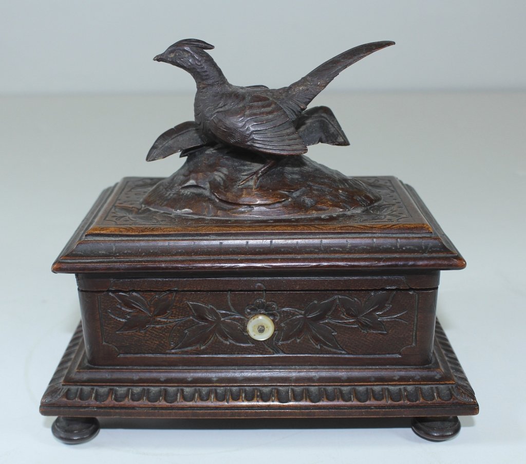 Black Forest Music Box: Black Forest carved music box, pheasant finial in casket style case, key wind (included), playing at auction time. 6" x 6.25" x 4.5", very good condition.