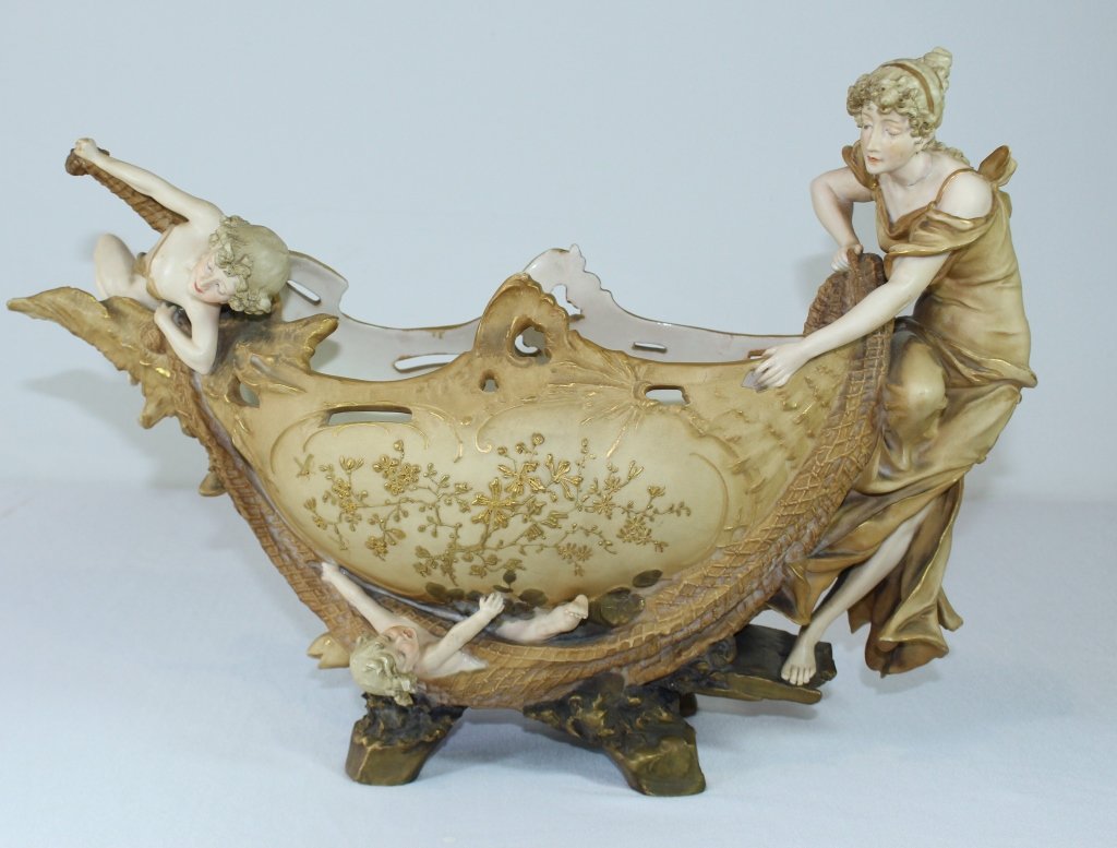 Ernst Wahliss, Amphora Center Bowl: Ernst Wahliss, Amphora Turn Wien, Vienna, Austria figural porcelain center bowl, maiden with fishing net catching a child and a fish in net, 12.5" x 18". One foot missing, head of maiden re-glued.