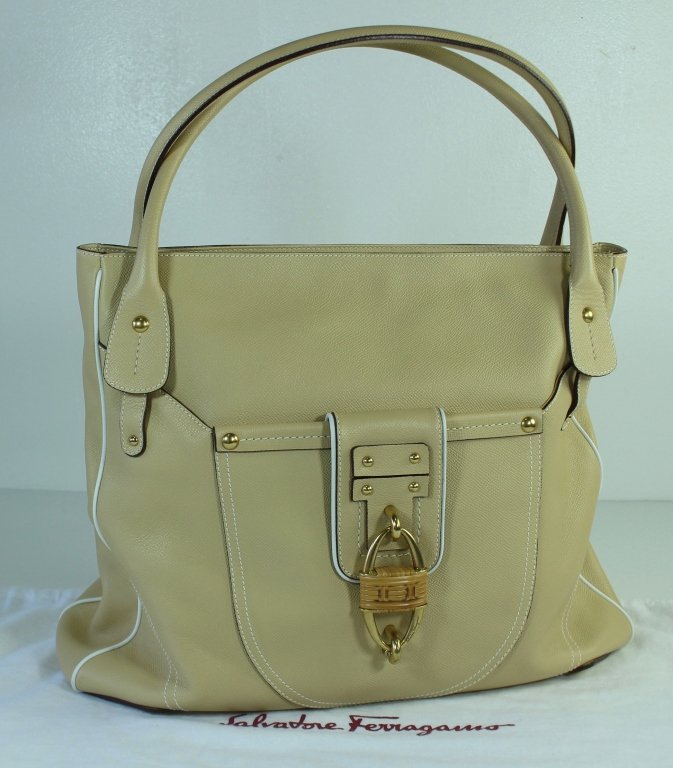 Salvatore Ferragamo Tote Bag: Salvatore Ferragamo tote bag, light tan leather with white thread stitching and white cord detail. Front pocket with lock and magnetic closure, brass stud accents. 14" h x 15" w, like new condition, i