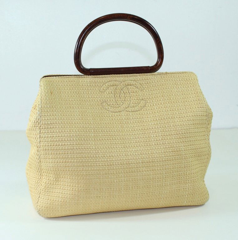 Coco Chanel Woven Straw Handbag: Coco Chanel woven straw handbag, burl wood ring handles, magnetic closure, fabric and leather interior, gently used condition with Neiman Marcus dust bag. 13" x 11" x 5".