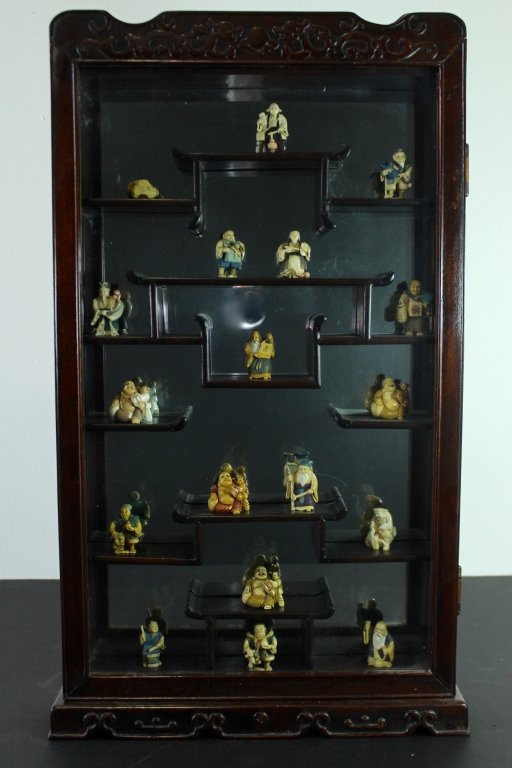 Oriental Curio Cabinet with Netsukes: Oriental style hanging curio cabinet filled with 18 carved ivory netsukes, exactly as it came from the estate. Cabinet is 28" x 16" x 4", mirror back with fixed shelving. Netsukes are in good conditio